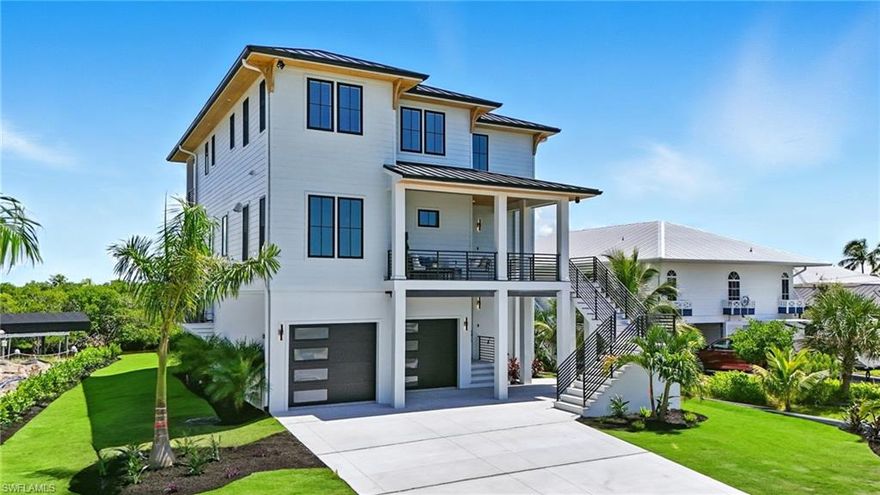 BRAND NEW, 2025 ELEVATED CONSTRUCTION, PANORAMIC BAY VIEWS!! A rare opportunity awaits with this brand-new custom-built luxury coastal retreat on Fort Myers Beach. Two stories over garage, an ELEVATOR delivers you to 2,936 square feet under air, this waterfront residence blends elevated design, storm-smart construction, and timeless coastal elegance, all set in one of the island’s most coveted locations. Positioned along a winding canal framed by natural mangroves, the property boasts a brand-new 60-foot Honc Marine seawall with a 2-foot concrete cap, a 10,000 lb. boat lift with canvas canopy cover, and quick, direct access to the Gulf of Mexico—making it a true boater’s paradise. From sunrise to sunset, enjoy sweeping views of the bay and Gulf from multiple vantage points, while direct beach access ensures the ultimate coastal lifestyle just steps from your door.

Built in 2025 with meticulous craftsmanship, the home features elevated construction with the garage raised 5.5 feet and second-floor living space soaring to 17.8 feet for enhanced storm resilience. Architectural details include cypress tongue-and-groove soffits, PGT black aluminum sliders, hurricane-rated windows and doors, and a deck drainage system for durability and low maintenance. Inside, hand-scraped engineered white oak flooring flows throughout, complemented by hardwood custom cabinetry, quartz countertops, and solid-core interior doors with flush-mount hinges. Designer-grade finishes, curated fixtures, and reveal drywall detailing elevate every space, while a private elevator services all levels for convenience.

The open-concept floor plan is flooded with natural light and extends seamlessly to rear bay view decks, where panoramic water views create the perfect backdrop for entertaining. Create lasting family memories around the sleek waterfall island of your chef's kitchen. A natural flame fireplace fueled by a 500-gallon propane tank adds warmth and ambiance, while the elevated three-car garage provides abundant storage and workshop space. Smart-home readiness includes pre-wiring and piping for a whole-home generator, dual 3-ton HVAC units for zoned comfort, and a Ring camera system for peace of mind. Outside, tropical landscaping with a six-zone irrigation system enhances the property’s coastal beauty. Pool renderings are for informational purposes only and not included. Introductions to pool contractors can be arranged. 

Located on prestigious Seminole Way, this home offers unmatched proximity to the Gulf, the beach, and the vibrant island lifestyle of Fort Myers Beach. More than just a residence, 306 Seminole Way is a statement of luxury coastal living—where resilience, design, and waterfront elegance meet.