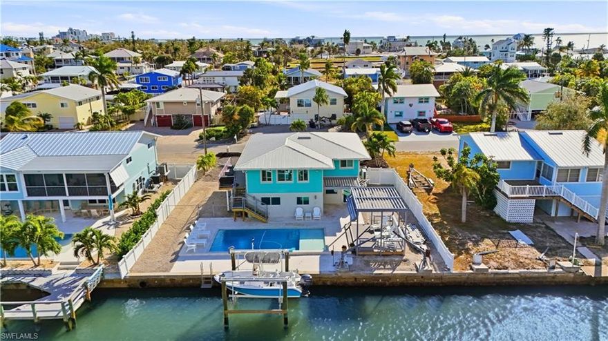 Beautifully remodeled and elevated, 7 Avenida Carita offers the perfect blend of modern comfort, thoughtful design, and resort-style living. Featuring two bedrooms plus a spacious den, this light-filled home includes two fully renovated bathrooms and luxury vinyl plank flooring throughout the main living areas and bedrooms, creating a cohesive and low-maintenance interior.

The kitchen is designed for both everyday living and effortless entertaining, offering abundant cabinetry, a breakfast bar, and seamless connectivity to the open-concept living and dining spaces. Walls of windows invite natural light, enhancing the warm and airy ambiance.

Significant improvements elevate this home to a true modern coastal retreat: a brand-new metal roof, impact-rated doors and windows, and new exterior stairs and elevated decking with custom powder-coated railings and composite decking. Outdoors, enjoy a newly designed pool by Jackson Pools, a private boat dock with lift, and a custom elevated metal pergola that completes the resort-style living experience.

Additional highlights include two one-car garages and a fully permitted enclosed nonconforming ground-level space, ideal for expanding your outdoor living, storage, hobbies, or flexible entertainment areas.

A new paver driveway, low-maintenance landscaping, and a prime location—just moments from the beach and Publix—make this property perfect as a second home or a strong income-producing rental. Turnkey and fully upgraded, 7 Avenida Carita is coastal living at its finest.