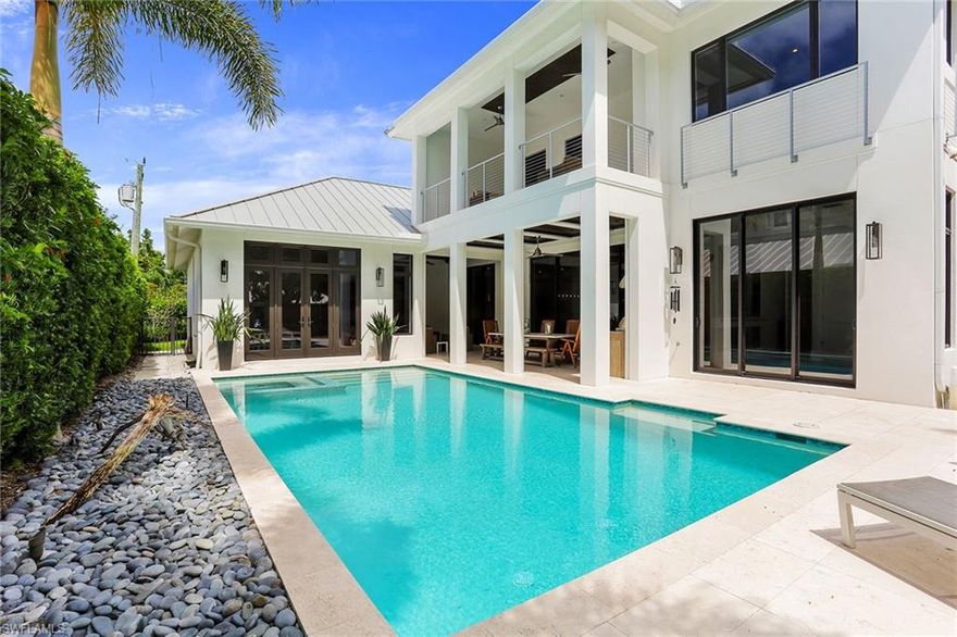 Celebrate indoor and outdoor living in this exceptional Old Naples home. Designed by local architect Stofft Cooney, this smart home boasts over 6,000 total square feet of open floor concept infused with natural light and comfort. Meticulously maintained, the five-bedroom plus den residence features beautiful architectural details that include wide plank wood flooring, a floating staircase with exposed supports, a great room with bar, and floor-to-ceiling glass doors promoting the covered outdoor space with summer kitchen, fireplace and heated pool and spa. The kitchen flanks the dining area and is highlighted by shaker-style cabinetry, marble backsplash, and pro chef designer appliances such as Wolf and Sub-Zero. The main level master retreat provides comfort with access to the pool area, dual walk-in closets with custom cabinetry, and a spacious bath with private courtyard garden viewing, dual vanities, and separate tub, and shower. The second level contributes to livability and accommodates three guest en-suites with a separate living area and terrace overlooking the pool. Close proximity to the beach and Old Naples’ amenities complete this perfect home.