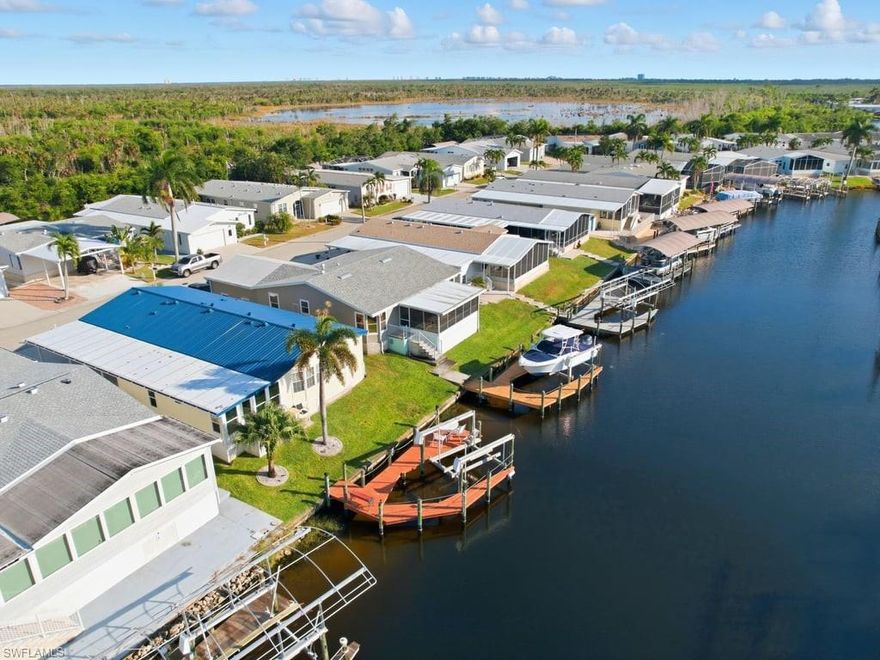 Welcome to your beautifully reimagined Coastal Craftsman home, perfectly blending timeless design, modern comfort, and Florida waterfront living! Thoughtfully renovated from top to bottom, this 2-bedroom, 2-bath home plus office/den with sleeper sofa offers nearly 2,000 sq. ft. of bright, open living space designed for style and relaxation. Step inside and immediately notice the attention to detail—custom craftsman trim work, handcrafted crown molding, and wide casings add character and warmth throughout. The open floor plan flows seamlessly from the spacious living and dining areas into a stunning, designer kitchen featuring granite countertops, premium cabinetry, stainless-steel appliances, and a large breakfast bar perfect for entertaining. A recently finished sunroom extends your living space, offering peaceful canal views and an abundance of natural light. The primary suite serves as a private retreat with a spa-inspired bath, while the guest bedroom and office/den provide flexibility for family or visitors. Step outside to enjoy the newly screened outdoor lounge, ideal for morning coffee, evening gatherings, or simply soaking up the Florida sunshine. Boaters will love the private dock with boat lift and captain’s walk, offering access to the scenic waterways that define this sought-after coastal community. A new metal roof provides energy efficiency and peace of mind for years to come. Located just minutes from Southwest Florida’s most beautiful beaches, Fort Myers Beach, Sanibel Island, Captiva, Bonita Beach, and Naples. This home is also conveniently close to great restaurants, shopping, and entertainment. Set within Bayside Estates, a highly active 55+ boating community, residents enjoy an exceptional lifestyle with resort-style amenities including a large heated pool, outdoor pavilion, clubhouse, shuffleboard, bocce ball, horseshoes, tennis, and pickleball courts. With endless social events and activities, you’ll quickly feel right at home in this friendly, vibrant neighborhood. Move-in ready and truly one of a kind, experience the perfect blend of craftsmanship, comfort, and coastal charm today!