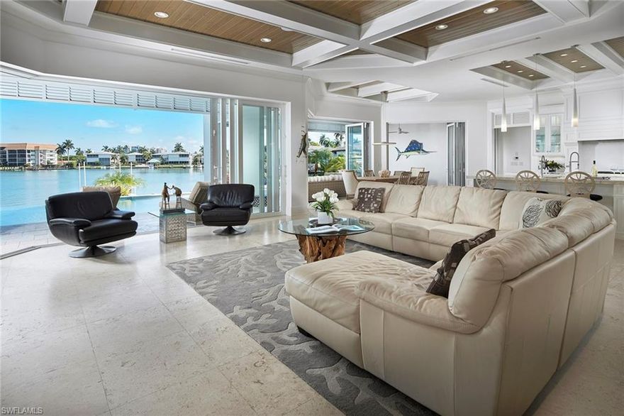 No bridges to the Gulf and wide western views of Moorings Bay, this recently constructed custom home is a coastal dream. Beachy shell stone flooring in the great room sets the tone for the light and bright finishes throughout. Double islands perfectly detailed with creamy Quartzite countertops enhance the gourmet kitchen with custom crafted cabinets by Ruffino and top of the line appliances. Bi-folding window walls separate the dining area to the covered lanai with outdoor kitchen making an easy setting to entertain family and friends. Well-equipped Butler’s pantry with wine cooler and quick access to the pool bath finishes the space. Guests will be delighted by the spacious four en-suite bedrooms to retreat to after enjoying time in the resort like outdoor area which is paradise found; including a generous negative edge pool, integrated spa, terraced seating areas, boat dock with boat lift and submergible jet ski lift, all with unparalleled views of the Bay. Ideally situated in the quiet Moorings neighborhood, just a short distance to the Moorings beach park, shopping and dining in either north Naples or downtown and the Gulf of Mexico.
