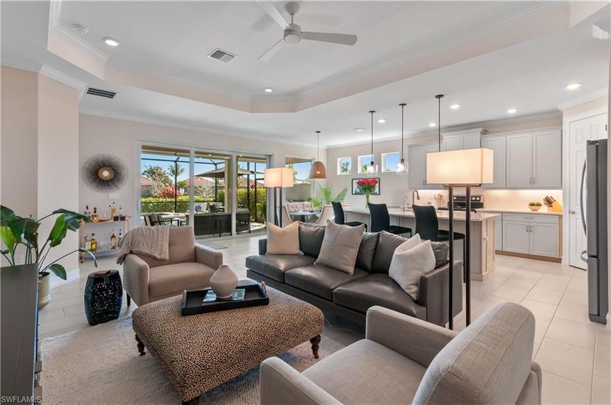 DESIGNER HOME WITH LAKE VIEW, OVERSIZED THREE CAR GARAGE & EXCEPTIONAL OUTDOOR LIVING AREA: 2,221 Sq. Ft. Under Air | 3,372 Sq. Ft. Total.  Showcasing the sophistication of a designer model, this impeccably appointed residence delivers a seamless blend of elegance, comfort, and resort-inspired living. Perfectly positioned on a premium end lot with serene lake views! This home offers 3 bedrooms, a private den, 2.5 baths plus a dedicated pool bath, 2,221 square feet of thoughtfully curated living space.
The expansive great room is designed for elevated entertaining, featuring soaring ceilings, refined architectural detailing, and recessed lighting that flows effortlessly into the gourmet kitchen and dining area. The chef’s kitchen is the heart of the home, appointed with an oversized quartz island, custom tile backsplash, stainless steel appliances, 42" upper cabinetry, and a spacious corner pantry—ideal for both everyday living and hosting in style.
Three hurricane-rated sliding glass doors create a dramatic connection to the outdoors, opening to a covered and fully screened lanai. Here a resort-caliber saltwater pool, spa, and wading area invite relaxation, while a private pool bath enhances convenience. The pool is fully automated and controlled wirelessly, allowing effortless enjoyment at the touch of a button.
The primary en suite is a tranquil retreat, featuring a generous walk-in closet with direct access to the laundry room. A spa-inspired bathroom with dual sinks, separate soaking tub and walk-in shower. Two additional bedrooms are thoughtfully separated for privacy and share a beautifully appointed bath. A den with French doors provides a flexible, refined space for a home office, media room, or guest retreat.
This home is enhanced with advanced Smart Home technology, including video doorbell, keyless entry, smart thermostat, lighting controls, and security features. The hurricane-impact windows and doors create a thermally efficient home to ensure your comfort, safety and peace of mind.
Completing the property is an oversized 3-car garage with a ceiling-mounted storage system, offering exceptional space for vehicles, golf carts, and recreational gear.
Seasons at Bonita – a 168-acre master-planned enclave with approximately 30 acres of scenic lakes and 548 single-family residences. Residents enjoy low HOA fees and an exceptional resort-style amenities, including a clubhouse, beach-entry resort pool with lap lanes and spa, tiki hut, fitness center, pickleball, tennis and bocce courts, dog parks, and miles of walking and biking trails.  This move-in-ready residence offers a truly elevated lifestyle in one of Southwest Florida’s most desirable communities.