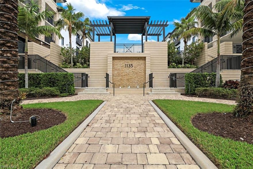 Experience luxury living at Naples Square with this turnkey condo, boasting southern exposure and gas cooking. The spacious, courtyard-level home features a private, extended lanai that blends indoor-outdoor living, with resort-style amenities just steps away, including a pool, spa, firepit, grilling area, and Club room. The gourmet kitchen offers Sub-Zero & Wolf  appliances, custom cabinetry, hardwood floors throughout the home, and quartzite countertops, perfect for any chef. Open-concept living with a built-in entertainment system, an electric vapor fireplace, motorized shades, and impact glass sliders enhance the space. The luxurious primary suite includes dual walk-in closets and a spa-inspired bath. Two additional bedrooms each have ensuite baths. Ideally located in downtown Naples' Design District, this home offers the best in luxury, convenience, and access to dining, shopping, and cultural attractions.