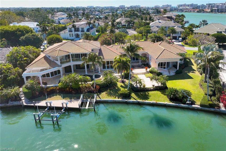 On one of the most desired streets in The Moorings, this incredible bayfront retreat offers a rare opportunity to create your dream. The property is on a .76-acre double lot, featuring 238 feet of street frontage with an expansive yard and 158 feet of pristine water frontage. The stunning views of Venetian Bay await, while the Gulf of Mexico is just a short boat ride from your doorstep. The residence, a spacious 7,735 square-foot home, has no history of water intrusion, according to the owner, and presents a canvas for remastering. Boasting five bedrooms, a dedicated study, six and a half bathrooms, a five-car garage, and multiple living and entertaining areas inside and out, this home offers a versatile layout that can be transformed into a luxurious masterpiece. Recent improvements to the home include new interior and exterior paint, air conditioner split units in the garages, updated landscaping, and a dock and boat lift with recent adjustments to accommodate a 30,000-pound vessel. Alternatively, capitalize on the rare potential to subdivide this property and build two spectacular waterfront homes, each with incredible views and direct access to the bay. This exceptional property is in the heart of The Moorings, offering available access to the private Moorings beach park and nearby access to the incredible shopping and dining at Venetian Village. Whether you choose to remaster the existing home or embark on a new development project, the location, views and privacy are unparalleled.