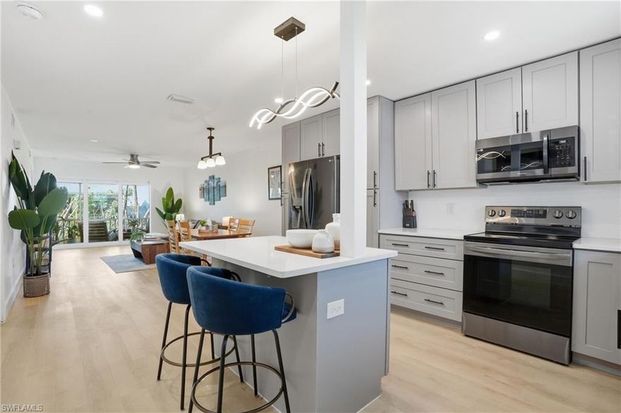 Modern coastal style meets low-maintenance Southwest Florida living. This move-in-ready second floor condo delivers designer finishes, impact-rated windows and doors for storm protection and peace of mind, and bright open spaces that instantly make you feel at home. Rare features include a deep 1-car garage with extra storage space and the added benefit of being located outside of a special flood zone. Luxury plank flooring flows throughout the home, while the thoughtfully designed open layout creates an inviting space for everyday living and entertaining. The renovated kitchen serves as the centerpiece of the home with quartz countertops, shaker cabinetry, open island seating, led lighting, and a seamless flow into the living and dining areas. Primary Bedroom with updated ensuite bathroom and walk in closet. Guest hallway with pocket door creates privacy with bedroom, bathroom and laundry, all tastefully updated. Deep 1 car garage with storage room for all your outdoor beach gear or seasonal items. The spacious screened lanai offers the perfect indoor-outdoor retreat for a cup of coffee or  to unwind at the end of the day. Triple slider opens fully to enjoy the Florida weather. Recent community improvements include newer roofs, fresh pavement, updated landscaping lighting, and refreshed landscaping. Residents enjoy a community pool, tennis and pickleball courts, and a convenient location close to shopping, dining, golf, and Naples beaches. Stylish, turnkey, impact-protected, and ready to enjoy from day one.