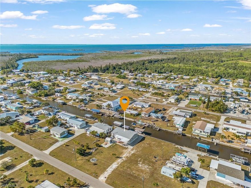 This stunning elevated triple-wide Jacobsen manufactured home which sits on .33 of an acre waterfront deep canal.   This waterfront home offers 1,875sq ft, 3 bedroom/2 bath of refined coastal living an showcasing exceptional craftsmanship and thoughtful design throughout. Impact-rated windows and doors, 9-foot ceilings with elegant crown molding giving the home a light, airy, upscale atmosphere.
The beautifully appointed kitchen is both stylish and functional, featuring a spacious center island, eat-in bar, quality appliances, abundant cabinetry, and large windows that flood the space with natural light. A separate dining area provides an inviting setting for gatherings as well as the 12’ x 25’ Florida room overlooking the tranquil canal.  The deep canal is direct access to the Intracoastal waterways, delivering world-class Pine Island fishing just minutes from your dock.   The 80'of waterfront includes a 7,000-lb covered boat lift plus an additional covered lift for a smaller vessel, along with a convenient fish cleaning station, perfect for an effortless day on the water. And let's not forget the 12x16 workshop/storage space, complete with electricity, perfect for hobbies and projects.  All this sets on .33-acre, THIS MERICULOUSLY MAINTAINED ELEVATED WATERFRONT HOME HAS NEVER BEEN FLOODED, OFFERING TRUE PEACE OF MIND AND STESS FREE CAOSTAL LIVING.
This home is located in in the desirable community of Flamingo Bay, with an optional HOA of $150.00 annual dues. HOA members enjoy access to a private boat ramp, community pool, and clubhouse, enhancing the relaxed coastal lifestyle. 
Come see this exceptional home and start your Florida lifestyle today!!!