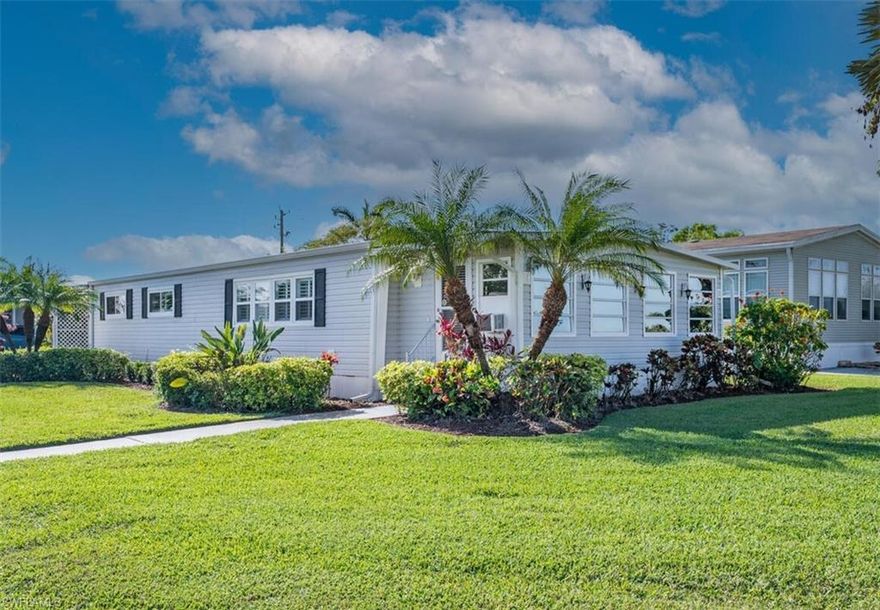 This lovely home has custom updates throughout that give it a polished feel, along with a spacious glass enclosed lanai that caters to creative endeavors. There is crown molding, plantation shutters on the windows, wainscoting in the dining room, a shiplap accent wall and French doors in the living room. The kitchen has been updated with natural stone quartz countertops, a new cooktop, tile backsplash, modern fixtures and more. Both bathrooms have been updated with quartz countertops, new toilets, a shower/tub in the GBA, and a walk-in shower in the Master BA. The oversized closet in the Master BR has room to accommodate a large wardrobe. You won't find any carpet, most of the flooring being vinyl planking. The washer/dryer are located inside the home so you can do your laundry in the comfort of A/C. There is a workshop in the detached shed for projects, and the home also has a water filtration system. This home has benefited from a tremendous amount of TLC, the property meticulously maintained. Riviera Golf Estates, a quiet and friendly 55+ community, has excellent amenities for just $144/mo. (includes your basic internet) - one of the lowest HOA fees in East Naples, and the  tennis/pickleball courts, heated saltwater pool, exercise room, billiards room, and clubhouse with active social calendar, are all just a two-minute walk from your front door. Everything inside the home is tastefully done with an artisan's touch. One of the nicest manufactured homes in Riviera Golf Estates, where YOU OWN THE LAND!