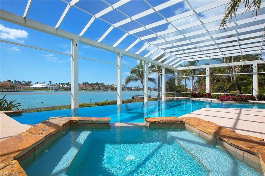 This spectacular, Estate area residence enjoys 287 feet of direct access water frontage on the 0.64-acre, southern tip-lot with sweeping bay views out to Caxambas Pass. This 2006, Slocum-Christian built home features nearly 5,000 air-conditioned square feet of barefoot luxury space with three-story elevator, five bedrooms, five-and-one-half baths designed with natural woods, neutral color palettes fusing the luxurious interiors with the home’s beautiful landscaping and waterfront setting. The most notable feature of the property is the outdoor living. Entertaining, relaxing and taking in the warm Florida sun and salty breeze takes place on a grand scale here from either your rooftop deck, nearly 3,900 square foot lanai with incredible bar, large pool (14x70) and spa or your bayside sun deck. For the avid boater, there is an awesome docking facility (3 years new) for all your water toys with three lifts (10k, 6k and 16k lbs.) Generator. New roof.