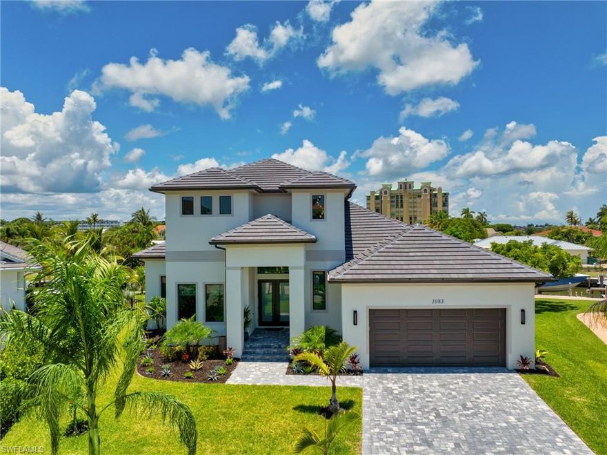 Discover an extraordinary opportunity to own a brand-new 2024 coastal estate wit 3-bedrooms, versatile den and loft on Marco Island, thoughtfully designed for those who expect nothing less than the best in waterfront living. Tucked away at the end of a quiet cul-de-sac in the historic Old Marco Village, this residence is a seamless blend of timeless architecture, modern amenities, and direct Gulf access—a true boater’s and angler’s dream with swift access to the ocean inlet in just minutes.

From the moment you arrive, the home’s clean-lined façade, manicured tropical landscaping, and new seawall with 109 feet of deep-water frontage set the stage for a one-of-a-kind retreat. The private dock features a 10,000 lb GEM remote-controlled lift that accommodates a 28-foot boat, with the option to expand for a larger vessel through Blue Marlin contractors. There’s also ample space along the seawall to add a jet ski or motorized kayak platform, perfect for maximizing your waterfront lifestyle.

Inside, light-filled living spaces are framed by soaring ceilings, expansive impact-rated glass, and panoramic canal views. Designer wood-plank tile, sleek linear air vents, quartz countertops, and custom lighting reflect the attention to detail found throughout. The chef’s kitchen impresses with custom cabinetry, luxury appliances, and generous prep space, while multiple gathering areas make the home ideal for both intimate living and large-scale entertaining.

The primary owner’s suite offers a private sanctuary, complete with a spa-inspired bath featuring a triple shower system and a private balcony overlooking the water—perfect for morning coffee. A second, junior primary suite is located on the main level, with its own full bathroom and direct access to the pool deck and lanai, ideal for guests or multi-generational living. Additional bedrooms, an oversized den, and a versatile loft with a private walk-in closet and balcony access provide flexibility for family, visitors, or a home office.

Outdoor living is at the heart of this property. The expansive lanai with a heated pool and sun shelf is surrounded by lush landscaping and enhanced by an outdoor kitchen and bar that rivals five-star resorts—featuring bar seating for six, a built-in AOG grill, Blaze refrigerator, Marvel ice maker with filtered water, and full sink. Evenings are unforgettable with professionally designed landscape lighting that transforms both the front and backyard into a warm, tropical oasis.

Additional highlights include CAT 5 and 6 wiring throughout for hardwired connectivity, flat-screen TVs mounted in every room for a streamlined look, a mini-split A/C in the garage, and warranties included for peace of mind. Dolphins and manatees are frequent visitors in the canal behind, adding to the magic of this coastal escape.

This estate is more than a home—it’s a lifestyle defined by privacy, elegance, and direct Gulf access on Marco Island’s coveted Paradise Coast.