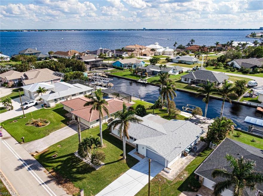 Welcome to your dream waterfront home in the heart of Cape Coral! This property features a spacious 1523 sqft, offering the perfect blend of comfort and style. Placed in a premium location, this property presents an unparalleled investment opportunity with its direct Gulf access. No locks nor bridges, ensuring you are mere minutes away from the river. Enjoy the a seamless boating lifestyle, as this residence comes complete with a lift and 40 ft dock with room for a bigger boat/sailboat, catering to those with a passion for sailing. Experience sunlight all day with south exposure, creating a warm and inviting ambiance. Enjoy the picturesque views of an intersecting canal while surrounded by million-dollar homes. The Royal Palms in the front and back yard add a touch of elegance to the overall appeal while your backyard serves as a tropical oasis with banana trees! This property is not just a home; it's an investment in a coveted waterfront lifestyle with possibility of additions with space available on the property.