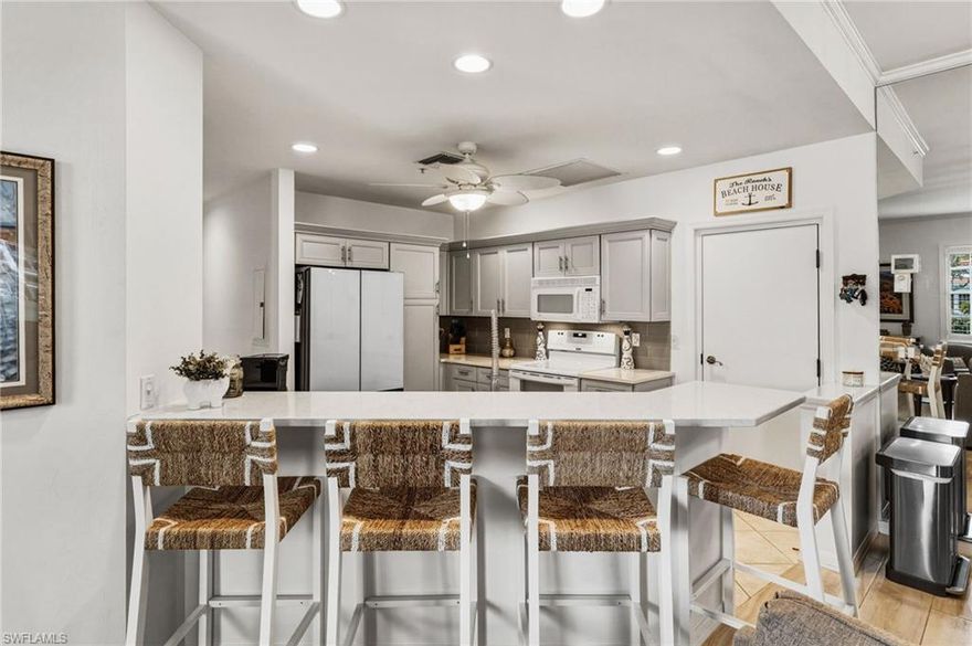 Nestled within the highly sought-after Harbour Links enclave of Gulf Harbour Yacht & Country Club, this beautifully maintained, move-in-ready residence offers an effortless blend of elegance and comfort—complemented by breathtaking sunset views each evening. Offered turnkey furnished and ideally positioned on the first floor, the home includes a private two-car garage just steps from the community pool. A gracious great room floor plan welcomes you in, flowing seamlessly to a screened lanai that captures sweeping lake and golf course vistas across the 10th fairway.

Inside, tile flooring extends throughout the light-filled living spaces, enhancing the home’s airy, refined ambiance. The thoughtfully updated kitchen is both stylish and functional, featuring quartz countertops, a farmhouse sink, new light gray cabinetry with soft-close doors and drawers, pull-out pantry shelving, a breakfast bar, a wine cooler, and a full suite of white appliances. Additional upgrades include a new refrigerator, tankless water softener, and a 2022 A/C system, while plantation shutters throughout add a timeless, upscale touch.

The spacious primary suite serves as a private retreat, complete with a well-appointed en-suite bath. The seller is graciously offering a credit to support the bespoke renovation of the primary ensuite bathroom, allowing you to curate a space of refined luxury tailored to your vision.   A bright and inviting guest bedroom offers comfort and privacy, while the second full bath is enhanced by a seamless glass enclosure with a chic barn door design. The versatile third bedroom, featuring glass-paneled French doors, is ideal as a den, office, or additional guest accommodations.

Further elevating the home are electric storm shutters, designer ceiling fans, extensive crown molding, and a two-car garage with built-in storage and a workbench. Optional private memberships are available, offering access to Gulf Harbour’s world-class amenities and an elevated lifestyle of leisure and luxury.