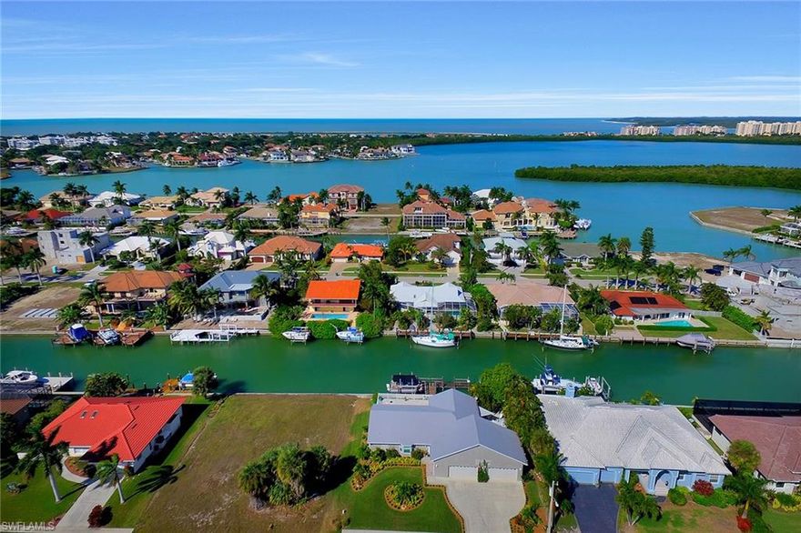 Enjoy the beautifully updated desirable Tigertail Beach residential area that gives quick and easy water direct access to the Gulf of Mexico from your large T-shaped dock with lift. This light and bright turnkey furnished four-bedroom, four-car-garage home boasts a brand-new kitchen which includes stainless steel appliances, breakfast bar, living and dining area, family room, remodeled baths, wood look vinyl flooring, special lighting and new impact glass windows and sliding glass doors.  Relax poolside on your open lanai with spa or lounge and linger on the lovely landscaped side patio. Start living the perfect island lifestyle today! This is a must-see, walk-through home and will not last. The front door, garage doors and side door are not impact glass.