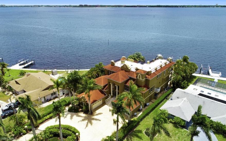 Southern exposure meets resort style living, in this custom built riverfront home. An entertainers delight! Enjoy the wrap around views overlooking the resort style pool and spa. A few steps away is your dock with two 20,000 pound boat lifts, tiki huts and jet ski lift. All at the mouth of the Caloosahatchee River, and minutes to the Gulf. 

Relax in the privately gated home, free of all HOA fees and live in this highly desired neighborhood, lined with beautiful Royal Palms. This home has the finest upgrades and features inspired by the owner. Walk in the Grand Entry and be mesmerized with the custom millwork, columns, ceilings and views galore! Come up into a spectacular two story library, where you can relax, listen to music or read a book by the marble fireplace...and it doesn't end there! 

The endless features of this home include: an elevator, storm shutter, sonos music system inside and outside, exercise room with sauna, billiard room with custom bar and wine cellar, four car garage with a separate motorcycle garage, along with two full size generators!