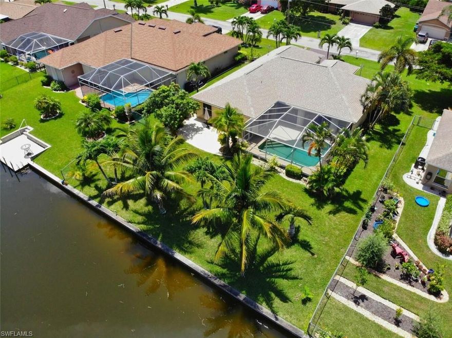 This beautiful waterfront pool home is being sold TURNKEY. Please keep in mind when looking, this home is fully furnished, much of which is large, Tommy Bahama style furniture. This unfortunately makes the home feel smaller, and in some cases blocks sliders or windows.  The entire home can be empty at closing, but the price includes a turnkey purchase. The roof is only 3 years old, and the property is NOT in a flood zone. Enjoy 4 bedrooms, a large Owner's Bathroom, pool access bathroom, large  kitchen with granite countertops, recessed lighting, stainless steel appliances, a formal dining room, family room, formal living room, & eat in kitchen. Living in Florida means sitting poolside, overlooking the water, cool drink in your hand. With a spacious screened in lanai, pool, and extra patio/BBQ area, your guests will feel like they are at a resort. Other features: automated sprinkler system, indoor laundry with sink, pantry, mango tree, tropical palms, shower & garden tub, dual sinks, tile in the living areas, plenty of cabinet space and storage, wide canal view, roll down and accordion hurricane shutters, crown molding, tray ceiling in the Owner's Bedroom, sliders to the pool area.