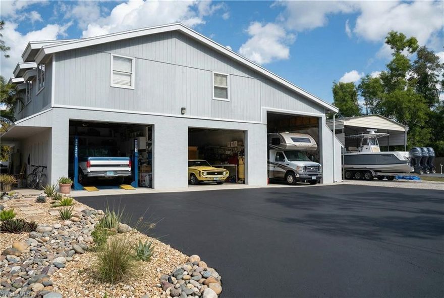 The ULTIMATE live/work property in San Carlos Estates starts with what truly sets it apart — a detached three-bay garage with vehicle lifts and a fully independent 2-bedroom, 1-bath apartment above, creating unmatched income-producing and business potential in the heart of Bonita Springs, centrally located between Fort Myers and Naples just minutes to US-41. The private garage APARTMENT offers its own spacious living area plus flexible green room/salon space, office, and storage/inventory rooms, ideal for rental income, multigenerational living, guest quarters, or a thriving home-based business. Below, the mechanic’s dream garage features three oversized bays including lifts, an extra-deep bay perfect for RV storage, Boat storage, Auto restoration, Painting, or Heavy equipment, along with a dedicated office, full bath, and laundry. Situated on 1.25 beautifully landscaped acres and zoned AG2 with no HOA, 100% UPLAND, AND NO FLOOD INSURANCE the property also includes expansive metal-covered parking and an additional concrete pad for contractors, car collectors, tradesmen, or entrepreneurs needing workshop space and equipment storage. The 4,000+ SQUARE FOOT, two-story MAIN RESIDENCE is move-in ready with a BRAND NEW roof, BRAND NEW vinyl siding, fresh professional interior paint, expansive custom kitchen, and oversized living areas, offering the perfect blend of luxury estate living, acreage, privacy, and commercial flexibility in one of Bonita Springs’ most desirable acreage communities.