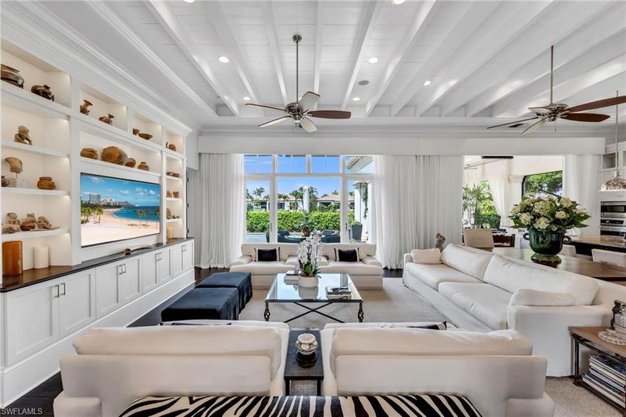 Thoughtfully designed by Stofft Cooney Architects and masterfully built by Diamond Custom Homes, this exceptional residence in Torino at Grey Oaks reflects a refined, open-concept lifestyle where sophisticated design meets effortless entertaining. Upon entry, the great room floor plan reveals a sense of volume and flow, enhanced by rich espresso wood flooring, bespoke architectural detailing, and abundant natural light through impact windows and doors.

The main living spaces evoke the ambiance of a boutique European retreat, with the great room and dining area opening seamlessly to the outdoors through expansive sliding glass doors. Custom built-ins, distinctive ceiling details, espresso wood flooring, and softly draped, full-height white curtain panels lining the walls create a layered, refined aesthetic, while curated finishes offer warmth and understated elegance.
At the heart of the home, the chef’s kitchen is both beautiful and highly functional, featuring custom glass-front cabinetry, an expansive island for preparation and gathering, and thoughtful details for the culinary enthusiast, including integrated knife storage and a discreet countertop chute. A suite of high-end appliances and a well-appointed pantry complete the space.

The primary suite offers a serene and private retreat, enhanced by custom architectural detailing, French doors, and generous dual walk-in closets. The spa-inspired bath is finished in exquisite marble, with dual vanities, a marble-clad shower with mosaic inlays, and refined designer touches.
Two additional guest suites provide comfort and flexibility, each with well-appointed baths, while one may also serve as a stylish office or den. Plantation shutters, custom cabinetry, wood flooring, bespoke built-ins, and designer wall coverings contribute to the home’s cohesive character.

Outdoor living is equally compelling. The expansive screened lanai is designed as a natural extension of the interior, complete with automated screens, motorized awnings, and a beautifully appointed outdoor kitchen. Draped in soft white curtains, the space offers a relaxed, resort-like setting for al fresco dining and entertaining.
Modern conveniences include a whole-house generator, tankless gas water heater, automated sunshades, and updated systems. Located within Torino, a natural gas community, the residence also offers a two-car garage.

Grey Oaks is one of Naples’ most prestigious private golf communities, offering three championship golf courses, two clubhouses, and four dining venues. Residents enjoy a 30,000-square-foot Wellness Center with spa services, tennis, pickleball, bocce, and a vibrant social calendar. Ideally located near downtown Naples, the Gulf’s white-sand beaches, and exceptional shopping and dining, Grey Oaks delivers a lifestyle defined by ease, connection, and understated luxury.  This is a one of a kind Torino residence...welcome home!