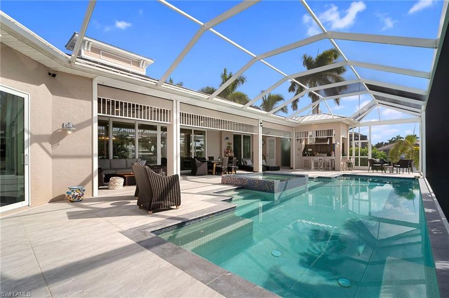 Welcome to this exceptional Luxury Gulf Access Home, perfectly situated on a massive intersecting canal in one of Southwest Cape Coral’s most desirable neighborhoods, just minutes from Cape Harbour. Offered fully furnished, this residence delivers breathtaking water views, refined coastal design, and serious boating appeal.
The open-concept floor plan is anchored by a gourmet kitchen featuring built-in stainless steel appliances, a spacious center island, granite countertops, and an oversized walk-in pantry with an additional cooler—ideal for entertaining or extended stays. Expansive living and dining areas are framed by 20-foot-wide, 9-foot-high sliders, creating a seamless connection to the outdoors. The primary suite is a private retreat with stunning pool and canal views, coffered ceilings, and two walk-in closets with wood-ventilated shelving. The spa-like bathroom impresses with a freestanding soaking tub, dual vanities, and a large walk-in shower with multiple shower heads. Each additional bedroom offers its own bathroom with walk-in showers, and one bedroom enjoys direct lanai access. High-quality plantation shutters are installed throughout all bedrooms and dens. Designed for comfort and efficiency, the home features two AC systems, separating the bedroom wings from the great room and kitchen. The great room flows effortlessly to the lanai with cypress wood ceiling, complete with a TV feature wall, electric fireplace, dining space, and a cozy lounge area. The lanai includes a separate pool bath, an additional enclosed shower, and electric roll-down shutters protect the lanai when needed. Outdoor living is next-level. You'll find a fully equipped summer kitchen with marine-grade grill, hood, sink, refrigerator, and a striking 90-degree angled bar. The solar-heated saltwater pool features an extended bench and a dramatic knife-edge spa, perfectly positioned to capture uninterrupted views of the canal intersection. The oversized, fully tiled pool deck sits on a concrete sub-deck and is enclosed with panoramic screens, offering unobstructed water views to both the rear and side. For boating enthusiasts, this property truly stands out.  Along the seawall, enjoy a captain’s walk, a 12’ x 12’ tiki hut, and a 16,000-lb boat lift with canopy, making this a boater’s dream. The extended garage includes an epoxy floor, mini-split AC, ample storage, workspace, and room for motorbikes and toys.
Whether you’re looking for a full-time luxury residence, an upscale second home, or a high-performing vacation rental, this modern coastal waterfront home delivers location, design, and lifestyle—without compromise.
