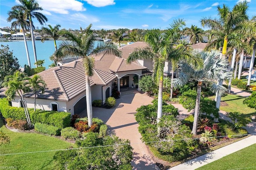 This exceptional custom-built home is on an oversized lot with stunning wide water views of Fredericks Bay. Deep water quick direct access out to the Gulf of Mexico through Caxambas Pass. This spacious two-story, five-bedroom plus den, 4.5-bath residence has everything you need with a formal living area, wine room and wet bar, updated gourmet kitchen with breakfast area, new appliances, beautiful cabinets, and adjacent warm and welcoming family room that can be used as additional dining area. The fifth bedroom comes with custom-built-ins which can also be used as an office/art studio. Enjoy the morning sunrise from the outdoor coffee patio or captivating sunsets from your expansive outdoor veranda with pool, spa and summer kitchen. The primary suite retreat offers dual sinks, bidet, with separate tub and shower. The second floor offers privacy for guests with a second primary bedroom and private balcony to enjoy stunning bay views. This home has an abundance of storage that includes walk-in closets in every bedroom. A large composite dock with a 16,000-pound and a 6,000-pound lift provides the ideal opportunity for the boater enthusiast and includes your own air-conditioned dock storage. Impact glass, manual and electric shutters, over-sized three-car garage and circular driveway.  Surrounded by lush tropical landscaping. Make this your slice of paradise today!