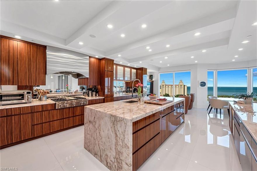 Totally renovated and reconfigured, this high floor 4-bedroom, 4.5-bath end unit was transformed into a contemporary and sophisticated interior, yet is an inviting space for family and friends designed by Janet Bilotti Interiors. Various walls were removed to create a more open plan. All ceilings were treated to coves or beams and LED lighting for art, mood and living. Doors and hardware replaced throughout. Motorized shades added to smart house control system. Custom glass entry doors welcome you as you step off the elevator with 30-in sq high-gloss white porcelain flooring sweeping into the open salon and dining area. Custom cabinets including glass wine display cabinets and buffet with backlit crystallo top. Kitchen cabinets were by Premier Custom-Built in PA. They consist of book-matched Rosewood, mixing high gloss poly rub and buff sheen. The countertops are fabricated from crystallo quartzite including mitered edges and waterfall ends. Bedrooms and den were finished with European wide-plank, oil-finished white oak. Enjoy this one-of-a-kind residence in the gated enclave of Bay Colony with the privileged use of its private beach, tennis and beach club.