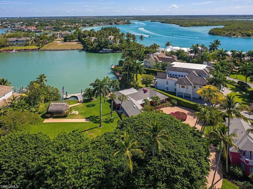 Outstanding opportunity to purchase nearly an acre on the bay just around the bend to the Gulf of Mexico, in the ultra-luxe enclave of Port Royal. The two contiguous bay-front lots provide expansive water views and are home to an astounding 60 ft. floating deep-water concrete dock, chickee hut, four bedroom guest bungalow, separate carriage house with 2 additional bedrooms, kitchen and family room, and three indoor parking bays set amidst a canopy of majestic banyan trees.  Property being offered as is. Port Royal Club membership eligibility.