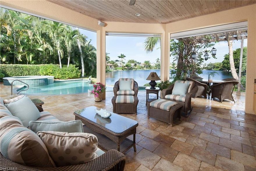 Waterfront. Old Naples. Perfectly situated on coveted Spring Lake in Old Naples, dramatic long lake views draw your eye the moment you enter this spacious home. Offering five bedroom suites, separate library office, and includes a separate au pair suite above the garage. This home is large enough to accommodate your closest friends and family while still offering everyone their privacy.  Delight in a chef's kitchen with gas cooking. A separately air-conditioned garage with ample storage closets makes it easy to care for those scooters and bicycles. 2005 construction affords wind rated doors and windows.  Enjoy the water views from your infinity pool and spa, then retire to the restful, covered outdoor living area with spacious seating around the fireplace and outdoor kitchen. Remote control screening easily incorporates the space into the house for perfect indoor-outdoor entertaining.  If you can pull yourself away, walk to Fifth Avenue restaurants for lunch, Third Street restaurants for dinner, and Naples sugar sand beach for sunset. That ‘close-to-everything’ neighborhood feeling right in the heart of Old Naples.  And that view.