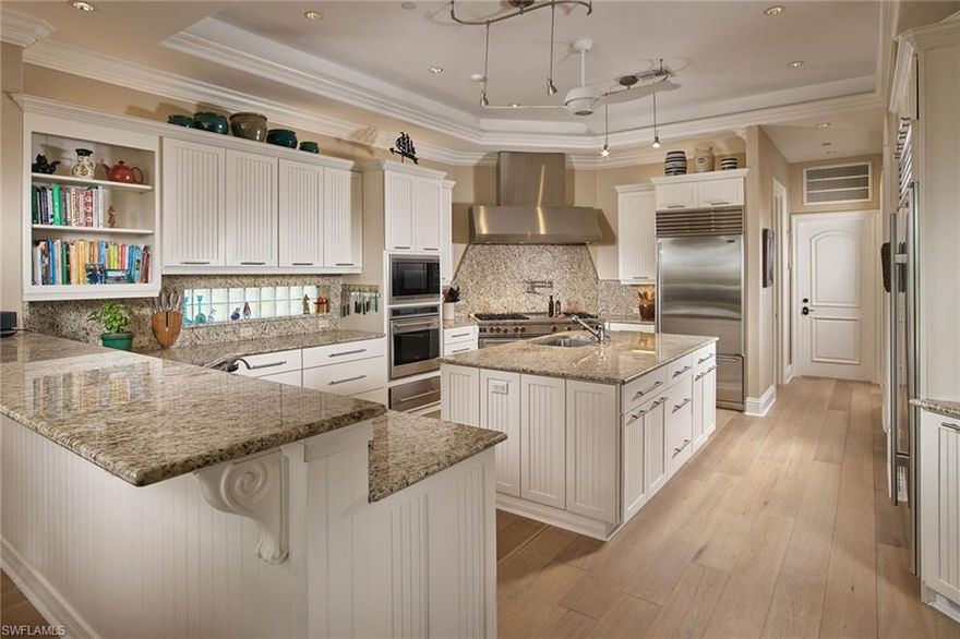 Southerly views from this Caribbean-style Aqualane Shores residence are stunning as they open up to the east and afford sunset skies to the west. Through the rich Mahogany front door, be greeted with light Siberian Oak wood flooring keeping a casual ambiance to the classic moldings of the foyer fireplace and detailed ceilings. The easy-flowing floor plan allows for a spacious open kitchen leading directly into the family room and outdoor space beyond, a spacious upstairs master suite and two offices on the first floor, easily converted to a first-floor master.  With soaring ceilings, an abundance of windows providing natural light, a spacious infinity-edge pool and an expansive dock with a sailboat lift, this home is your Aqualane Shores dreams come true, all located on the quiet 21st Avenue South, just a quick golf cart ride to all Naples is best known for.