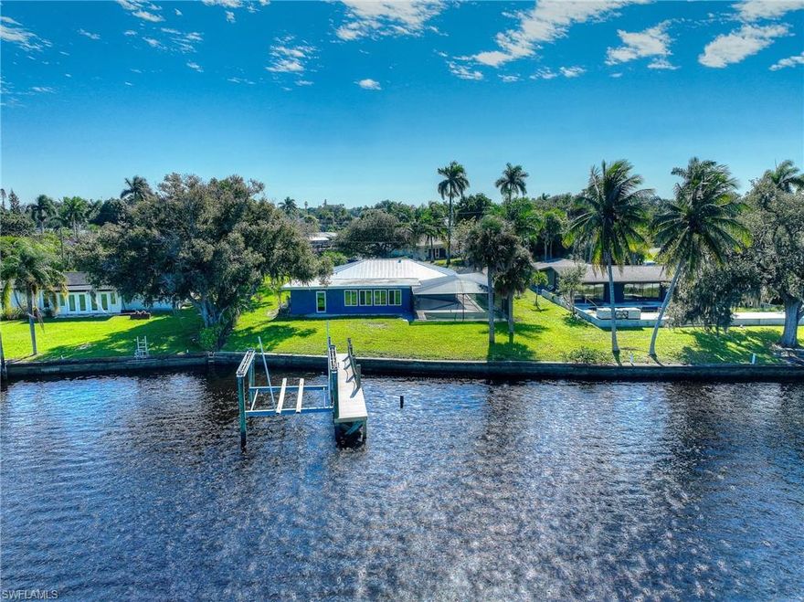 One or more photo(s) has been virtually staged. Experience the pinnacle of Florida living in this stunning, newly remodeled split-floorplan home, ideally located on the enchanting Caloosahatchee River with gorgeous views of Beautiful Island. With your very own dock and lift, you’ll enjoy seamless access to the Gulf, making every boating adventure a breeze. As you step inside, you'll be mesmerized by the expansive water views that greet you from the open-concept living area. The kitchen is a chef’s dream, featuring brand new appliances, elegant granite countertops, and generous cabinet space. The adjacent dining area invites you to soak in the picturesque views with access to the lanai, making it the perfect spot for entertaining or relaxing. This inviting space flows effortlessly into the living room, your new sanctuary for indoor leisure. Retreat to the primary bedroom, strategically positioned at the back of the home for added privacy, where you'll be treated to serene water views and direct access to the backyard. On the opposite side of the house, the two guest rooms offer comfort and charm, one of which overlooks the pool. A conveniently located guest bathroom serves both rooms perfectly. Exceptional renovations include hurricane impact windows, a durable metal roof, a modern kitchen and bath, and a new A/C system, ensuring peace of mind and comfort. This home truly checks every box for the ideal Florida lifestyle. Don’t miss out on your dream home—schedule your showing today!