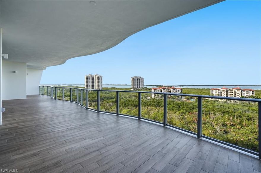 Welcome to a brand-new coastal residence at Infinity at The Colony, where elevated design, breathtaking Gulf and water views, and a resort-style lifestyle come together effortlessly. Positioned high above the shoreline, expansive glass frames sweeping vistas and fills the home with natural light from the moment you arrive.

Step inside via your private elevator and into a bright, contemporary interior with soaring ceilings and an open layout that lives beautifully, whether you are hosting or enjoying a quiet evening at home. The upgrades feel intentional and refined throughout. Wood flooring runs through all bedrooms, bringing warmth and continuity to the private spaces. In the kitchen, upgraded quartz surfaces create a clean, polished statement, complemented by a tiled backsplash that adds a tailored coastal finish. A matching quartz wet bar makes entertaining seamless, while J-boxes above the island are already in place, ready for the pendant lighting that completes the designer look.

Glass doors open to an oversized lanai with a built-in grill, inviting you to dine al fresco, unwind with morning coffee, and take in the changing sky over the water. A second private outdoor space adds even more flexibility for lounging, hosting, or simply enjoying the breeze.

Beyond your front door, Infinity offers a full suite of amenities designed for comfort and ease, including multiple resort-style pools, a poolside restaurant, a member’s lounge, a game room, and a state-of-the-art fitness center. Recreation continues with pickleball courts and a PopStroke-style golf experience designed by Tiger Woods’ architect, plus thoughtful pet amenities like an on-site dog spa and dog park. Evenings are elevated on the rooftop terrace with an outdoor kitchen and firepits, all complemented by 24-hour concierge service and access to The Colony’s private island beach park and the waterfront Bay Club.

This is coastal luxury with intention: upgraded finishes, expansive outdoor living, and a curated amenity lifestyle that feels effortless every day.