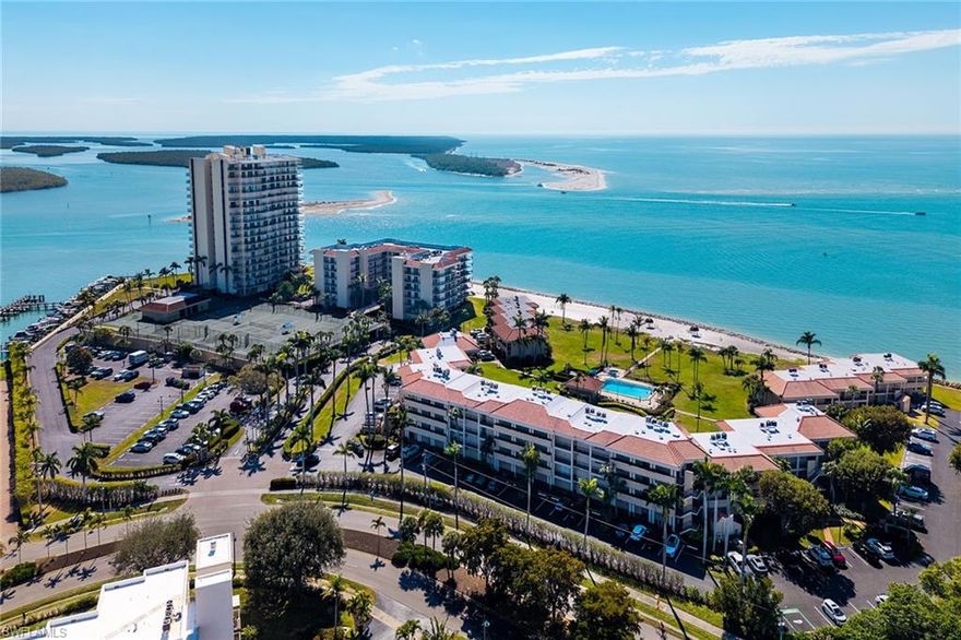 Experience the pinnacle of coastal living in this stunning two-bedroom, two-bath waterfront condominium at south end of Marco Island. Wake up to a beautiful sunrise and the shimmering water views of the 10,000 islands from your private lanai. The moment you go in the front door, you are greeted with a wall of sliding doors looking out to the amazing water view. The well-maintained condominium features spacious rooms and large walk-in closets in both bedrooms, manual hurricane shutters and plenty of kitchen cabinets.  All rooms have sliding doors that lead to the newly tiled private balcony. The complex amenities include tennis, fitness, shuffleboard, kayak storage in the covered parking garage, and a heated pool with a spa overlooking the expansive water and the 10,000 islands. Skip the crowds. Enjoy exclusive access to a pristine, private stretch of sand just near your front door. Boat slips are available for rent and currently have a waiting list for a slip with a lift. Whether you're watching dolphins play from your balcony or enjoying the lush, tropical grounds, this is more than a home, it's a permanent vacation.