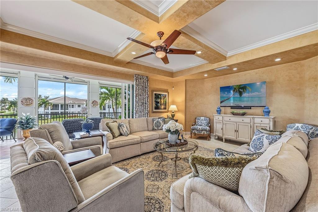 Luxurious living room in a three-bedroom condominium featuring a stylish design, comfortable seating, decorative accents, and views of the Avellino Isles community.