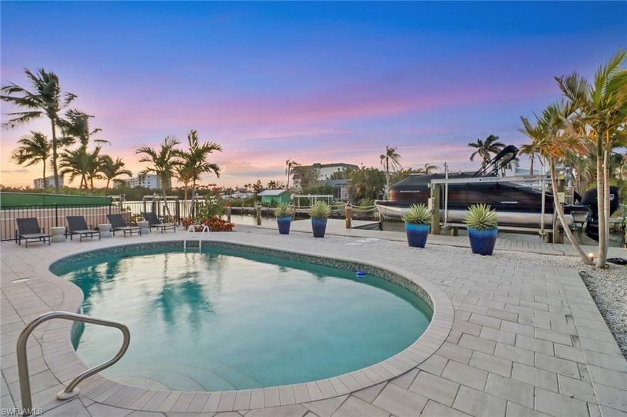 STUNNING WATERFRONT OASIS - Take advantage of one of the finest estates in Little Hickory Shores, a premier boating community of Collier County. This 2003 well built home boasts a sprawling floorplan with vaulted ceilings, impeccable design, split bedroom suites, and multiple living and dining areas, ideal for entertaining. The outdoor space feels like a resort with brand new elevated seawall, massive dock with sundeck, 10,000 pound boat lift, as well as new pavers and glass tile around the sparkling and heated pool. Inside, the chefs’ kitchen features ample freshly painted cabinetry, double oven, generous pantry, built in desk, stainless steel appliances and oversized island for gathering. The kitchen and living areas wrap around a screened lanai with new tongue and groove wood ceiling, and stunning views at the end of the canal and out over the bay. The master bedroom wing is a true retreat with oversized bedroom and sitting area, western windows to take in sunset, double closets and a spa bathroom with two vanities, soaking tub and separate shower. A 5th bedroom/office completes the west side of the home. The east wing features a second master with en-suite bathroom and French doors for privacy. The south wing has two additional guest rooms which share a spacious bathroom with dual sinks, jetted tub and separate shower.  Upstairs is completed by a large laundry room and newly refreshed half bath with nickel slot detailing. The new owners will LOVE having ALL living area upstairs across one floor to avoid flood risks, fresh paint inside and out, as well as a myriad of storage and linen closets, neutral diagonal tile, Minka aire fans, new light fixtures and thoughtful details throughout. Additional upgrades include decorative Bahama shutters, new metal spiral staircase to downstairs, accent walls, wood ceiling details, and more. Downstairs has room for 4+ cars + storage, and a massive rec room, outfitted with durable flooring for additional living and bonus space, as well as a full size bathroom for downstairs access from the pool or potential bedroom spaces. Incredible location in Collier County, just a mile to award winning beaches, and a couple blocks to over a dozen popular restaurants including Docs Beach House, Coconut Jacks, Enzo’s, Bonita Fish House and more!