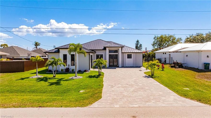 Check out the 3D interactive tour on the link provided and check back for video tour!! Welcome to this beautifully upgraded waterfront home built in 2020, perfectly situated in a PRIME central Cape Coral LOCATION just off Veterans Parkway and Santa Barbara Boulevard, close to Cape Coral High School, shopping, restaurants, and everyday conveniences. This thoughtfully designed home features 3 bedrooms plus a den and 3 bathrooms, including TWO SPACIOUS PRIMARY SUITES, making it ideal for guests or multigenerational living. Inside, you'll find CUSTOM CLOSETS, designer touches, and ELECTRIC BLINDS in the main living area and primary bedroom, creating both comfort and convenience throughout the home. The property is also equipped with IMPACT-RESISTANT WINDOWS AND DOORS, offering added storm protection and peace of mind. The open living space flows seamlessly to the outdoors where Florida living truly shines. Enjoy the EXTENDED LANAI overlooking the canal, a beautiful pool with a BAJA SUN DECK, and a fully equipped OUTDOOR KITCHEN—perfect for entertaining or relaxing in your private backyard retreat. The home also offers ideal SOUTHER EXPOSURE, providing sun on the pool throughout the day and the perfect setting for enjoying Cape Coral’s outdoor lifestyle year-round.  Recent upgrades include a MATTE BLACK METAL ROOF installed in 2022 and SOLARS PANELS that keep the ELECTRIC BILL UNDER $50 per month, providing both durability and exceptional energy efficiency. With modern construction, thoughtful upgrades, and an unbeatable central location, this home offers the perfect combination of style, functionality, and Florida waterfront living.