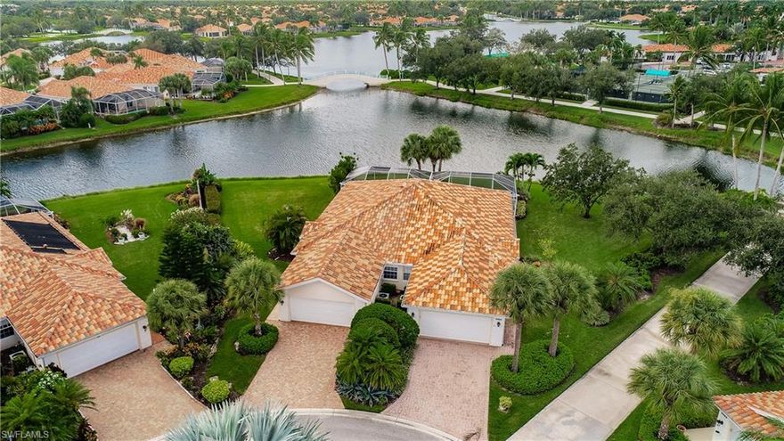 It's all about the location and views from this super premium lot!!  Wide pie shaped lot provides special venetian bridge and lake views as well as an easy walk to tennis courts and town center.  This extended Capri was constructed with poured concrete, has an oversized screened patio, roll down hurricane shutters, and tile in all living areas and laminate floors in the bedrooms.  Many appliances have been replaced and this home has a new roof!  Village Walk is 5 miles from Vanderbilt Beach and the popular dining and shopping areas of Mercato.  Most residents of Village Walk are full time and there are activities and amenities available all year round.  Come see this special location and make it your own!