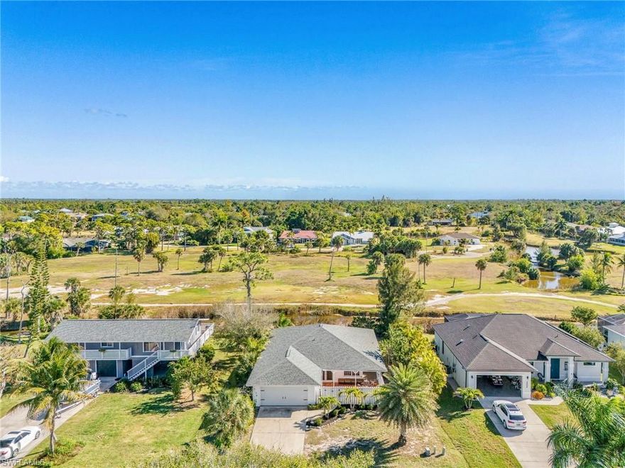 This beautifully updated 2 bedroom, 2 bathroom, 2-car garage elevated home at 14112 Clubhouse Drive in Bokeelia delivers classic island character, modern updates, and the kind of location that makes people say, “We should’ve bought sooner.” Designed as a tasteful nod to the Keeper’s Cottage at the Sanibel Lighthouse, this home captures that timeless coastal look—without requiring you to warn ships, trim wicks, or live in isolation. Just solid charm, smart design, and a front-row seat to Pine Island living done right.

The elevated construction offers both peace of mind and perspective, and the home has no history of flooding, which on an island is the equivalent of finding parking right by the dock—rare and deeply satisfying. Step out onto the private front terrace, the perfect spot to sip coffee, judge the weather, or wave knowingly at neighbors who didn’t get in early. Around back, a full-length porch stretches across the home and overlooks the soon-to-be renovated and reopened golf course, meaning your view is about to improve and your timing couldn’t be better. Golf courses reopening tend to work miracles on property values, and this one is no exception—consider this your early adopter bonus.

Inside, the home has been thoughtfully and tastefully updated, including a new kitchen that’s ready for everything from casual island breakfasts to post-fishing feasts, and updated bathrooms that feel clean, comfortable, and refreshingly current. Large windows throughout flood the home with natural light, making the space feel bright, open, and cheerful—no cave vibes here. The elevated layout captures breezes and views while keeping the home practical and low-stress, because island living should be relaxing, not complicated.

The location checks every box and then casually adds a few more. You’re minutes from Pineland Marina, where boats, sunsets, and waterfront dining are part of daily life, and close to Tarpon Lodge, one of the island’s most beloved destinations for food, atmosphere, and stories that may or may not get better with retelling. Pine Island’s unique blend of Old Florida charm, local flavor, and unspoiled beauty surrounds you, offering fishing, boating, dining, and exploring without crowds, high-rises, or pretense.

Whether you’re looking for a full-time home, a seasonal escape, or a smart investment with upside, this property delivers. It’s elevated, updated, well-located, flood-free, and positioned perfectly ahead of rising values tied to the golf course revival. In short, it’s the kind of place that lets you enjoy island life now and feel very clever about it later.