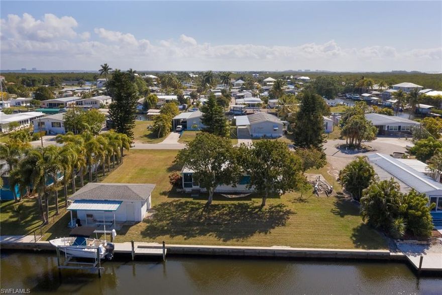A boaters & fisherman's dream, with room to spread out! This private island oasis is on TWO lots, with 120’ of waterfront. The rare Double Lot is on 84' wide Direct Access Deep Water Canal: No Bridges to deal with & Just Minutes to Open Water & some of the Best Fishing In The World! This Updated manufactured home is in a high-end area, off 8th Ave. It features an open great room floorplan, new kitchen w/granite countertops, wood cabinetry, breakfast bar & stainless appliances. Light & bright w/newer windows & new flooring. Large master suite w/built ins & Guest room w/Murphy Bed. Big screened lanai w/outdoor kitchen area perfect for entertaining. Detached 15x25 CBS garage w/ covered patio perfect for watching dolphins & manatees play right from your Composite dock w/Boat Lift (new in 2015) & 120' Seawall (2012). Plenty of parking w/attached carport & cement pad. Lots of Room for a Pool, RV and all your toys! The perfect Tropical Island setup located minutes from Pine Island Sound and Intercoastal Waterway, allowing easy navigation to the famous beaches of Sanibel, Captiva, Cayo Costa & Boca Grande. Plus only a golf cart away from local bars & restaurants. This gem won't last!