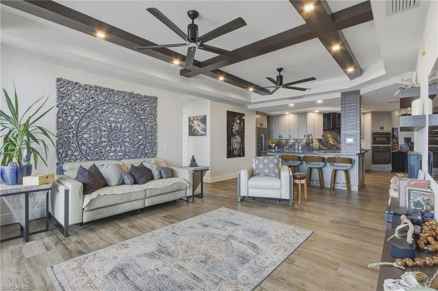 Step into luxury living in this fully reimagined 3-bedroom, 2-bath waterfront condo at The Riviera in Downtown Fort Myers, offering 1,571 sq ft under air plus an additional 250 sq ft of screened lanai space. This exceptional home showcases a comprehensive interior renovation blending modern architectural design with premium natural materials and custom craftsmanship throughout.
A refined sense of style is evident from the moment you enter, highlighted by architectural wood ceiling beams, a custom wood column wrap, handcrafted floating shelving, and seven solid-core modern interior doors. Three custom built-in closet systems add both beauty and function. Porcelain plank flooring extends seamlessly through the entire residence and out onto the lanai, creating a cohesive indoor-outdoor living experience.
The designer kitchen is a showstopper, featuring ample custom cabinetry, natural quartzite countertops, a Franke workstation sink system, Brizo fixtures, integrated under-cabinet lighting, and a professional appliance suite including induction cooktop, built-in ovens, counter-depth refrigerator, and dishwasher.
The spa-inspired primary bathroom offers a serene retreat with custom quartzite stone surfaces, chevron stone flooring, full tile surround, an undermount soaking tub with waterfall front, custom cabinetry, designer lighting, and a frameless glass shower enclosure. The primary bedroom is elevated further by a Graham & Brown Bespoke designer wallpaper feature wall. The elegant guest bath features marble flooring, textured wall tile, custom vanity cabinetry, premium fixtures, and a frameless glass enclosure.
Additional luxury finishes include quartz and quartzite stone surfaces throughout, a custom Dekton porcelain built-in dresser, designer lighting with multiple dimmable zones, toe-kick lighting, recessed fixtures, and upgraded interior and exterior ceiling fans. 
This condo offers a rare combination of modern luxury, thoughtful design, and high-quality craftsmanship. Residents enjoy an array of resort-style amenities, including an infinity-edge pool overlooking the river, a state-of-the-art fitness center, theater room, library, and community room for social gatherings. Outdoor enthusiasts will appreciate the tennis and pickleball courts, gas BBQ grills, kayak launch, and an adjacent park for pets. An active social committee and on-site management ensure a vibrant, well-maintained community. All of this is just a short walk or seasonal trolley ride from downtown Fort Myers’ lively restaurants, boutiques, and cultural events like Art Walk and Music Walk. Finally, you will have peace of mind knowing that this financially sound community has fully funded reserves, with no deferred maintenance, and has completed their Structural Integrity Reserve Study.