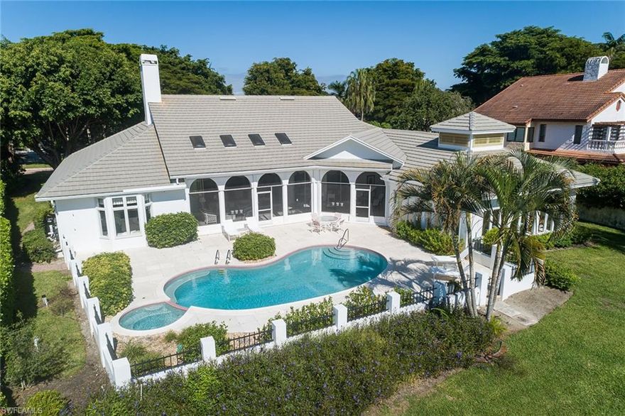 Perched on one of the most prime lots in all of Pelican Bay, 708 Nathan Hale is a sundrenched jewel box that sits on a southern exposure 0.42-acre lot with long sparkling lake and panoramic vistas in the sought-after gated enclave of Georgetown. This home exudes charm and timeless Old Florida flavor with a floor plan that rivals today's open living spaces with soaring 16-foot ceilings, large windows and 8-foot pocket sliding doors. The fine woodwork and architectural detail abound throughout the home and every space is supersized, offering a total of over 4,500 square feet under air and over 8,400 in total area. The dramatic signature fireplace and built-ins define the space beautifully. The covered screened piazza is massive (over 700 square feet) and overlooks the sparkling lake views and large pool, spa and deck space. The versatile and extremely sunny guesthouse offers 800 square feet, beamed ceilings, an abundance of floor-to-ceiling windows, large open space, full kitchenette and large bath. Roof was installed in 2015, electric and manual hurricane shutters, circle driveway, oversized garage with extra storage, and no flooding during Hurricane Ian completes the package. Georgetown is one of the prized gems of Pelican Bay, with its interior, sound-proof location, gorgeous, oversized lots, loads of brand-new homes mixed with classic, timeless homes, and a 24 hour guard-gated entry. Pelican Bay residents also benefit from a myriad of five-star amenities, including two fabulous newly renovated beachfront restaurants, tennis courts, pickleball, biking and recreational trails, and a state-of-the-art fitness and life center with a full gym, spin classes, yoga and more. Indulge in a lifestyle of elegance and sophistication in this Pelican Bay gem!