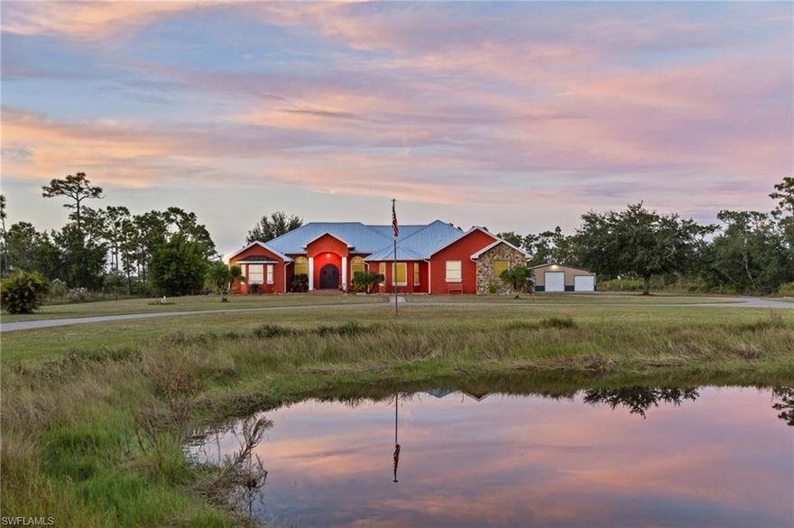 Set on more than 3 acres, this impressive 4-bedroom, 5-bathroom estate (3 full, 2 half) delivers a rare mix of luxury, peace, and space for equestrian living—all without HOA restrictions. Inside, soaring vaulted ceilings and an elegant fireplace anchor the expansive great room, creating a perfect setting for both relaxed living and entertaining. Hardwood flooring flows throughout, adding warmth and natural sophistication.

The kitchen is designed for the serious cook, featuring high-end appliances, a large island with storage on all sides, and a wine refrigerator—ideal for entertaining or everyday creativity. Granite countertops and a roomy breakfast bar complete the space with style and function.

The oversized primary suite serves as a private retreat, offering direct access to the lanai and pool area. The ensuite bathroom includes dual vanities, a soaking tub, and a separate shower for a spa-like experience. One of the guest bedrooms also has its own ensuite, perfect for use as an in-law suite, while the remaining two bedrooms provide plenty of flexibility for guests or a home office.

The screened lanai features electric shutters, an outdoor kitchen, and a heated saltwater pool with hot tub—an inviting setup for gatherings or quiet relaxation. The fully fenced and gated property includes an electric wire fence for added security, and a scenic pond enhances the tranquil atmosphere. Horses are welcome, making it ideal for equestrian enthusiasts.

Car lovers will appreciate the detached outbuilding (42' x 24'), complete with water and electricity, three bays that can accommodate multiple lifts, and ample space for yard equipment and tools. Along with the attached 2-car garage, you’ll find generous parking and storage options throughout.

This exceptional property combines refined living, equestrian amenities, and plenty of room to roam—an ideal retreat for those seeking privacy, comfort, and the best of the Florida lifestyle.