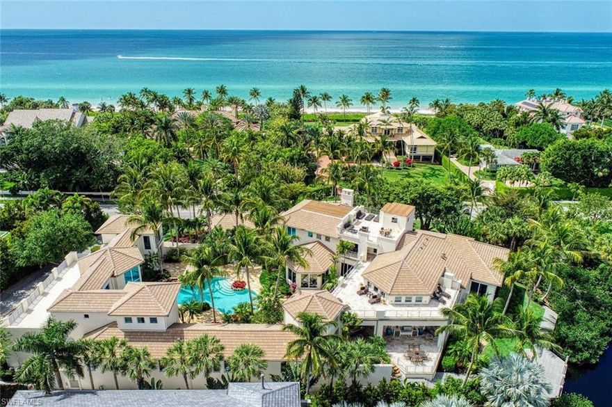 This one-of-a-kind estate speaks for itself! Over 11,000 s.ft. of precise craftsmanship offers perfection on a level not often seen in other homes, and perfectly placed in the heart of Naples between a tranquil lake and white sugar beaches of the Gulf of Mexico. Minutes from the renowned 5th Avenue with fine dining and upscale boutiques. A tropical oasis awaits you with an abundance of outdoor living areas, including multiple terraces and fireplaces surrounding a private and lushly landscaped pool, spa, and waterfall. Welcome your friends and family with an entirely separate guest wing and treat them to an al fresco dinner overlooking the lake and a nightcap on the rooftop terrace. Take in a movie in the impressive theatre or pamper yourself in the steam room after yoga in your gym. The owner's ensuite offers peaceful lake views, and a luxurious bathroom with his and her stylish vanities, grand showers and expansive walk-through closets. Born from a creative collaboration between architect Herscoe Hajjar, and two of the most established and finest custom home builders, A. Vernon Allen and Aerial Construction, this home exudes quality and exceeds all expectations.