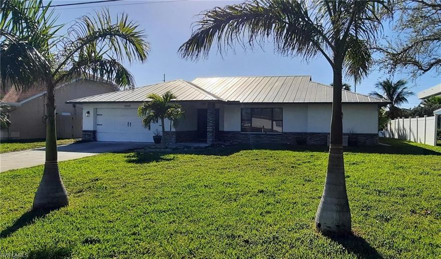 Welcome to your new waterfront retreat in in SE Cape Coral, offering direct Gulf access with no bridges. Situated on high ground in flood zone X500, this concrete block home has never come close to flooding and comes equipped with a durable metal roof and metal hurricane shutters for peace of mind. This beautifully remodeled home spans over 1,800 sq ft and features 3 spacious bedrooms, a den, and 2 bathrooms. The living spaces flow seamlessly through three sliding glass doors, leading out to the pool lanai, where you can relax and enjoy stunning sunsets with the home’s western exposure. The large concrete in-ground pool is perfect for year-round enjoyment. Inside, the home boasts tile throughout, with a modern kitchen showcasing granite countertops, a large island, an expansive tile backsplash, sleek cabinetry, and stainless steel appliances. The primary suite features a double-sink vanity and a tile walk-in shower, while the guest bathroom also offers a double-sink vanity and a bathtub with tile walls. This guest bathroom doubles as the pool bath for added convenience. All water, sewer, and irrigation assessments have been paid, making this home even more desirable. The Palaco Grande neighborhood offers a vibrant community with optional association activities like block parties and monthly happy hours, with no HOA rules or mandatory fees. Located approximately 20-minutes from Fort Myers Beach and close to shopping, schools, restaurants, and other amenities, this home is ideal for an Airbnb vacation rental, a winter retreat, or your everyday paradise.