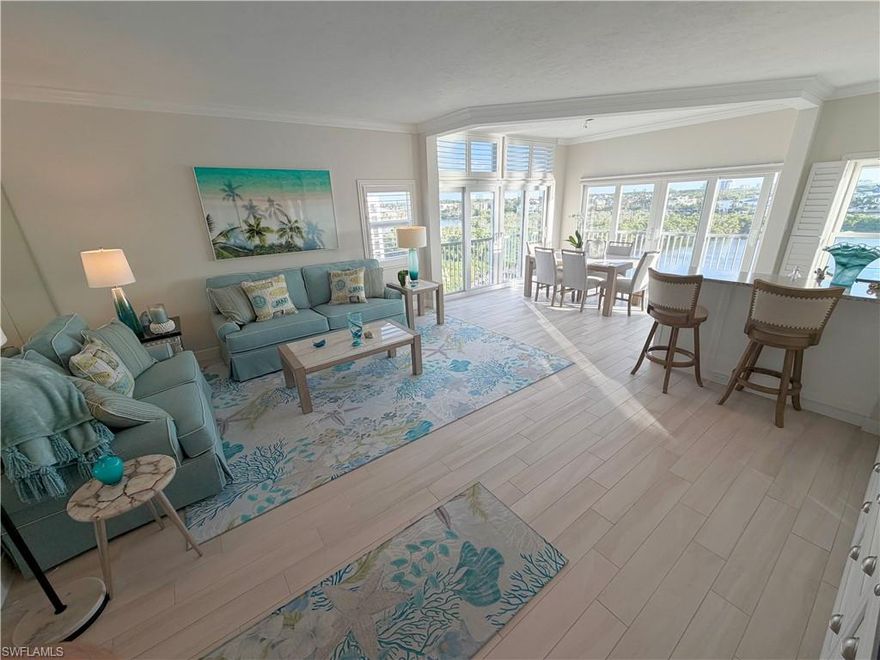 This stunning top floor, end-unit WATERFRONT Penthouse boasts 3 bedrooms & 2 bathrooms with bay views from all 3 sides, with higher ceilings than all the lower floors. This is the largest floorplan in the building.  Recently completely repainted and tastefully renovated, this slice of paradise showcases Florida's coastal living vibe. You are just 4 blocks to the beautiful, white sandy Gulf beaches.  This rarely available top floor condo screams beach living with an abundance of natural light, magnified by the newly installed full wall of mirrors in the great room, and great south-east/west exposures all day for the sunrises and sunsets.  Watch the dolphins and manatees play in Hickory Bay right below your main living and kitchen. Beautiful neutral tile flooring throughout, impact glass sliders/windows. Impeccable water views from all 3 bedrooms, one guest room has a custom built-in queen size Murphy Bed. Enjoy exterior dining out on the building patio with a gas grill off of the clubroom.  There is Gulf access from the many available community boat docks + kayak launch. One assigned coverd parking in garage and ample guest parking for building. Relax at the bayfront pool and hot tub, & walk to local restaurants, Coconut Jacks, Fish House or Docs Beach House on the sand. Upgrades to building include keyless entry, beautifully refurbished pool, elevator, and relaxing community room on 1st floor.  Enjoy Florida's finest waterfront living!