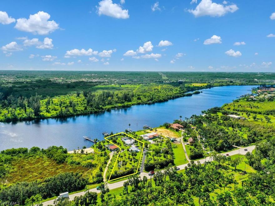 RIVERFRONT OPPORTUNITY! Very rare property with tons of potential - 1.6 acres situated right on the Caloosahatchee River (sailboat passible) with a 5 bedroom single family pool home, huge detached garage, gated entry into the property, and private boat dock. There was water intrusion caused by Hurricane Ian, the home has been completely mucked-out including the drywall being removed 4ft up from floor. This is your opportunity to make the home just the way you want it! The sprawling layout features a living & family room design, tons of natural lighting with almost wall-to-wall windows/sliders facing the river, kitchen situated off of the family room, in-residence laundry area, and a massive screened rear lanai that has a custom built pool. Just a few steps away from the home is a huge detached garage that has plenty of room for a workshop. Caloosahatchee River frontage in SWFL is highly desired due to offering a peaceful waterfront setting while being an intercostal waterway, plus you will have quick access via boat to the Gulf of Mexico.