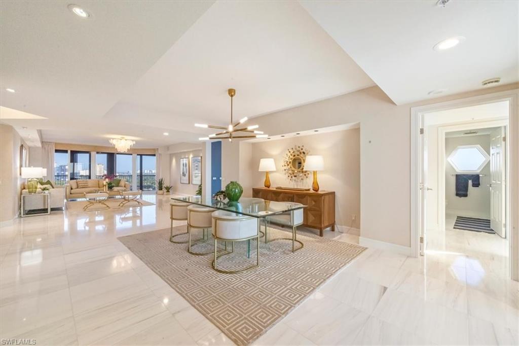 Designer-renovated luxury condominium interior featuring an open floor plan, elegant living area with high ceilings, modern dining space, and views of the Gulf of Mexico, located in the Montenero community.