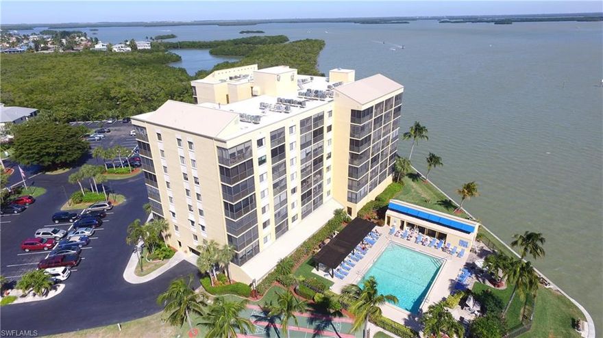 When walking into this unit you'll feel like you're sitting inside a wide angle lens camera. The panoramic scope of water views is immeasurable! As a corner unit, you are awarded the extra water views to the east of the bay as well as the spectacular long bay views to the south towards Big Carlos Pass bridge. This unit is nicely updated with granite counter tops, newer kitchen cabinets, brand new doors, tile throughout , need I say more!!!! Just imagine... sitting on your lanai watching the sunrise with a nice cup of coffee ,mother dolphin in the bay teaching baby how to hunt for breakfast and the manatees lazily swimming by eating their kelp. The fishing right off the seawall is some of the best of the beach and will keep you occupied for hours. There are plenty of great restaurants, shopping and a marina within walking distance . The large pool overlooking the back bay has plenty of room to take in a beautiful tan, do water aerobics or just plain relax. The white sugar sand beach and the Gulf of Mexico are just a short walk down the street. This unit has fantastic rental history. With all of this .. WHAT ARE YOU WAITING FOR?  SNOW? WE DON'T HAVE ANY !! MAKE YOUR APPT. TODAY!!