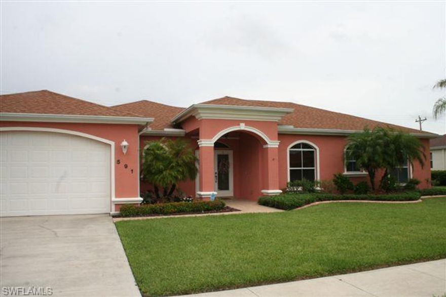 Gorgeous 2/2 home with den features soaring ceilings, crown molding & so much more! On the outside, from the new sculptured glass double front doors, beautiful landscaping, new exterior paint to city water & sewer & well & pump for irrigation. The front porch & walkway are attractively custom tiled. On the inside, there are French doors that lead into the den that features built in shelving & an inviting window seat. Family room also has built in shelving & is wired for surround sound. Roomy kitchen offers upgraded wood cabinetry & corian countertops, as well as pantry & bar.  Master suite includes 2 walk in closets, dual his & her sinks & a jetted Roman tub & shower. There is a monitored alarm, fans in most rooms & hurricane shutters are included. Indoor laundry room & large two car garage. This beautiful home invites you in & makes you feel welcome & at home! Close to Lehigh Acres shopping, restaurants, churches, schools. Less than 5 minutes away is Veterans Park Recreation Center with a K-8 public school on site. There are tennis courts, a full game room, weight room with locker rooms and 2 full sized basketball courts in the gymnasium. Come home to Lehigh Acres & SW Florida!!