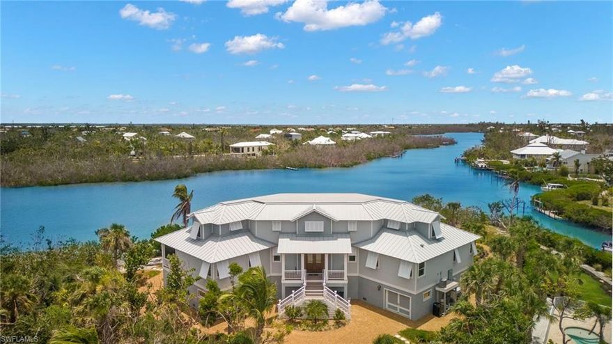 Simply The Best! Beautifully executed 2015 Old Florida style custom home perfectly sited on .50 ac. incredible view lot w/ almost 300 ft. Of Dinkins Bayou frontage, just a  7 minute walk to the beach! Only the finest finishes throughout- Custom Rutt Regency face frame cabinets, custom Tiger Oak interior doors, wide plank Bella Citta European Oak floors, Wolf Range, separate Sub Zero refrigerator & freezer, full wet bar, prep. sink, Artisan made "Sanibel" shell mirrors in the baths. Elevator, 4+ car garage, abundant storage, pool, spa, dock with 7k lb. boat lift, Kayak launch, direct Gulf and Sound access. This lovely home truly has it all inside and out w/ complete Interior & Exterior Architectural Detailing including gorgeous tongue & groove beamed ceilings, board & batt Wainscotting, Hardie Plank and Shingle style siding, Bahama Shutters and more.