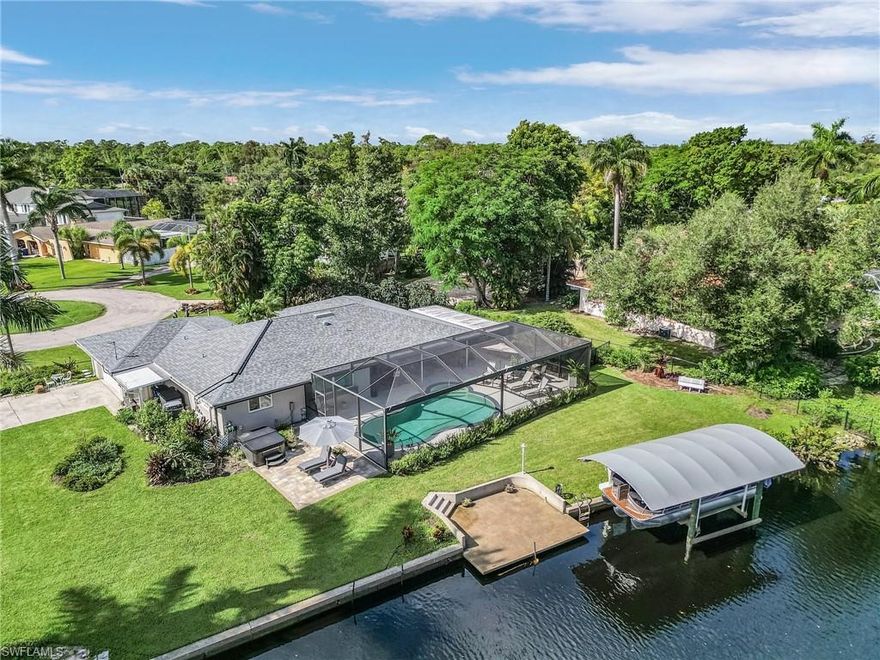 Do you like privacy, peacefulness, nature and boating?  Welcome to your new waterfront pool home on a quiet cul-de-sac with a panoramic view of a preserve on 229 feet of water frontage with a full seawall.   Lower your boatlift with a Gem Remote control for a ride to the Caloosahatchee River, nearby waterside restaurants, or all the way to Sanibel, Ft. Myers Beach, and the Gulf of Mexico!  Just a short bicycle, walk or golf cart ride from your new home is the neighborhood’s private 7-acre park with a direct access boat ramp, beach, pavilion, electricity, and sink with potable water.    All this for only $200 per year voluntary association membership (No HOA)!  There’s plenty of room to park your toys, relax at two paved seating areas and lower dock (with electric and water), fish, or just roam around in your .39-acre yard.  The 1,836 sq ft 3-bedroom, 2-bathroom home with 2-car garage was been completely updated with new roof in 2019.  2020 full-view 10’ cathedral expanded lanai with lots of covered area for seating and storage and water hook-up for your fridge.  The newly expanded oversized lanai with almost 2,000 square feet has a 29 x 17’ inground pool and is great for entertaining!  The Coastal interior décor features wood-look porcelain tile and matching granite countertops throughout, new two-tone gray and white quality wood cabinets with soft close doors and pull-out drawers and extra storage.  Plus, stainless steel appliances and hood fan.  Enjoy natural light from the front French level 7 privacy double doors or open them up to the screened front entry to let that beautiful Florida fresh air flow through the house.  All new 2023 Storm Smart hurricane windows and sliders throughout.  Save on your electric bill with the high-end variable speed A/C system with a 3-year transferable warranty covering both parts & labor plus variable speed pool pump.  All new duct work.  2017 Solar Pool Heater for year-round enjoyment.  2023 Boat Lift Remote and Canopy.  Doggy doors from the house to the lanai, and then to a 4-foot-high aluminum fence with gates on each end.  It’s camouflaged with Florida Friendly and Native plants.  That landscaping style extends throughout the property attracting birds and butterflies.  The spacious primary bedroom overlooks a patio and creek with separate his & her vanities and a walk-in closet.  The guest bath with a walk in frameless glass shower also has a hall pocket door so guests can walk from bedroom to bathroom with privacy.  The side-load garage has water hook-up for an additional refrigerator, built-in work bench and storage shelves.  This community has a Ladies Club, Book Club, and several Monthly events at the “Point” Park during “season”.  The neighborhood is just a short drive to shopping and restaurants, and only ten minutes to everything downtown Ft. Myers has to offer!  Come see how the 200 home private Yacht Club Colony neighborhood can make your waterfront dream a reality!  Make an appointment today!