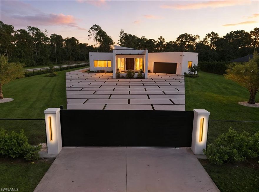 Discover this sensational modern estate in the highly desirable Golden Gate Estates community. Offering over 6,466 sq. ft. of living space on 2.81 private, fenced, and gated acres, this property is a serene retreat that perfectly blends luxury, design, and privacy. This custom-built masterpiece was crafted with exceptional attention to detail, featuring 4 spacious bedrooms, 4 full bathrooms, a chef inspired kitchen, and a striking glass enclosed wine cellar the perfect mix of sophistication and comfort. From the grand pivot wood door to the expansive impact windows that fill the home with natural light, every detail has been thoughtfully designed to connect indoor and outdoor living. The open-concept layout is ideal for both entertaining and everyday living. The primary suite offers a true spa like experience with a walk-in shower, dual vanities, a smart toilet, and custom wood cabinetry with quartz countertops. Conveniently located near the upcoming Vanderbilt Road Extension, this home provides quick access to the best of city life and the beaches just 20 minutes away. Experience unmatched tranquility, architectural elegance, and modern luxury the perfect place to call home. some pictures contain virtual staging.