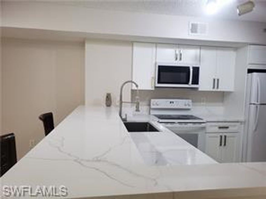 This is a first floor 2 bedroom, 2 bath condo in Napoli off Davis Blvd, within 15 min drive to downtown Naples and beaches. Painted a light taupe, luxury vinyl plank waterproof flooring, white shaker cabinets and quartz counter tops. The HVAC system is 2.5 years old. Napoli is a gated community and offers a nice clubhouse, a bocce court and tennis, large community pool, library, a billiards room, a fitness center, lounge area; located at the corner of Davis Blvd and County Barn Road in Naples FL. AC system  is about 3 years of age, water heater in 2022. Great location.