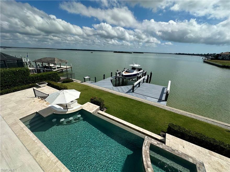 MAJOR $1 MILLION PRICE REDUCTION from $5,999,000! MUST GO NOW
Unmatched Views + Turnkey Luxury Living
Welcome to your forever home! Built in 2019 by Frey & Son Homes as their model showcase, this stunning residence combines modern luxury with panoramic wide water views and abundant wildlife. From the moment you arrive, the elegant architecture and seamless indoor-outdoor design set the tone for a truly unforgettable living experience.  Located just over the bridge and across from the Marco Island Yacht Club, enjoy quick boating access to the Gulf and 10,000 Islands. A 40,000 lb boat lift and separate launch for jet skis, kayaks, or a skiff make it a boater’s dream.  Inside, the open-concept floor plan is packed with high-end features: a private elevator, butler’s pantry and entrance for effortless entertaining, integrated stairwell wine chiller, and a cozy electric fireplace. Bay views grace nearly every room.  The outdoor living space is a showstopper—complete with an outdoor kitchen, infinity edge pool, hot tub, al fresco dining areas, and daily visits from dolphins, manatees, and exotic birds.  The main-level owner’s suite features private pool access, custom walk-in closets, marble inlays, and sparkling quartzite finishes. Also on the main floor is a flexible space for a home office or gym, opening to the pool deck near the outdoor shower.  Upstairs offers a spacious loft with wet bar, reading nook, and balcony perfect for sunset lounging or late-night pool games. The ensuite bedroom has a private coffee deck, while the central guest room offers stunning bay and sunset views. The kid-friendly bunk room sleeps six and includes a hidden “kid cave” for extra fun.  This home was designed for unforgettable gatherings and peaceful moments alike—set against nature’s most beautiful backdrop. It’s more than a home… it’s paradise, fully turnkey and ready for you.